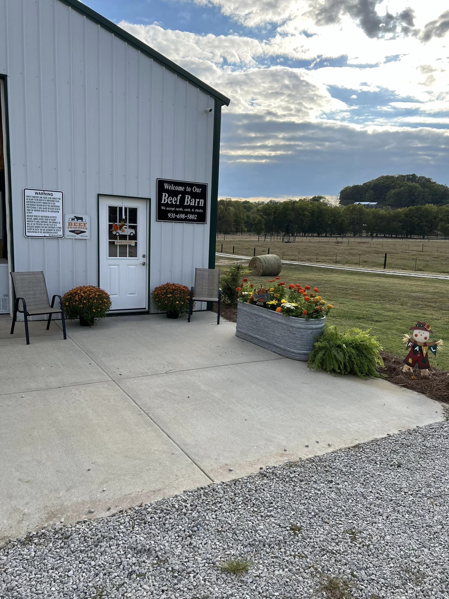 Entrance to The Beef Barn at Church Farms, with a welcome sign and flowers